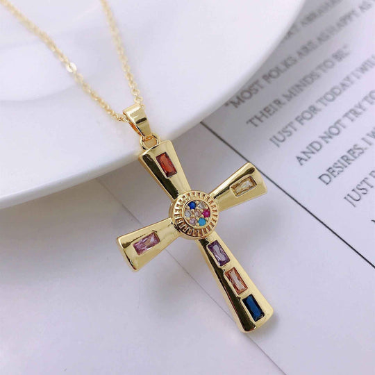 Goldfarbener Kreuz-Anhänger mit blau-rotem Stein in der Mitte und bunten Steinecken