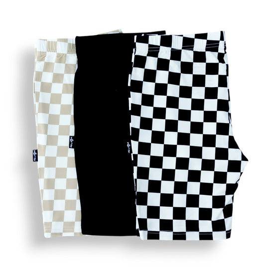 3-pack biker shorts folded: tan check, solid black, black-and-white check