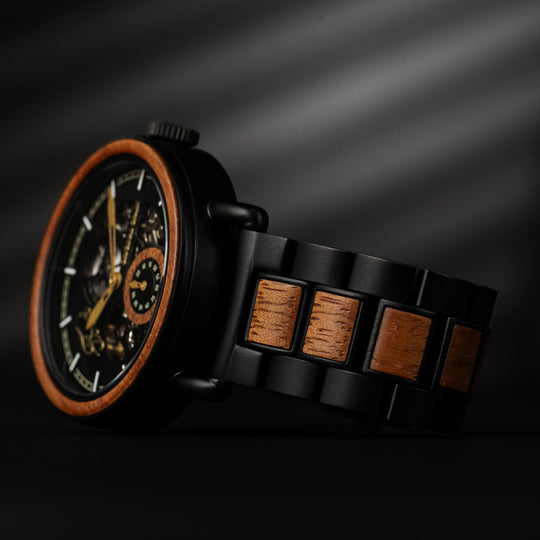 Watch bracelet close-up with black links and rectangular wood inlays