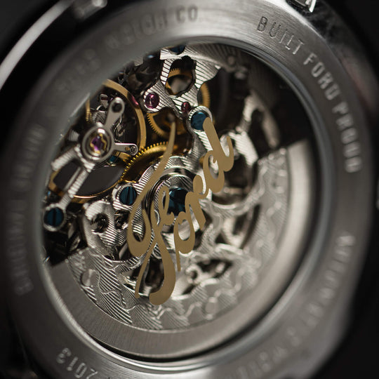Close-up of automatic watch movement with exposed gears inside the case