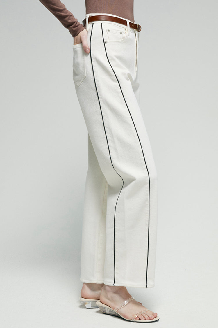 Side view of white ankle jeans with contrast piping and deep front pockets