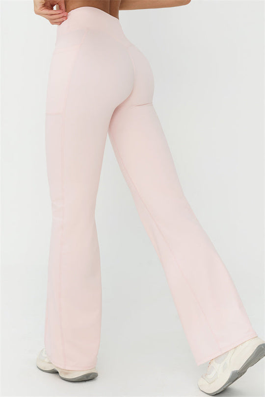 Light pink flared leggings with smooth seams and wide bell-bottom legs, full length