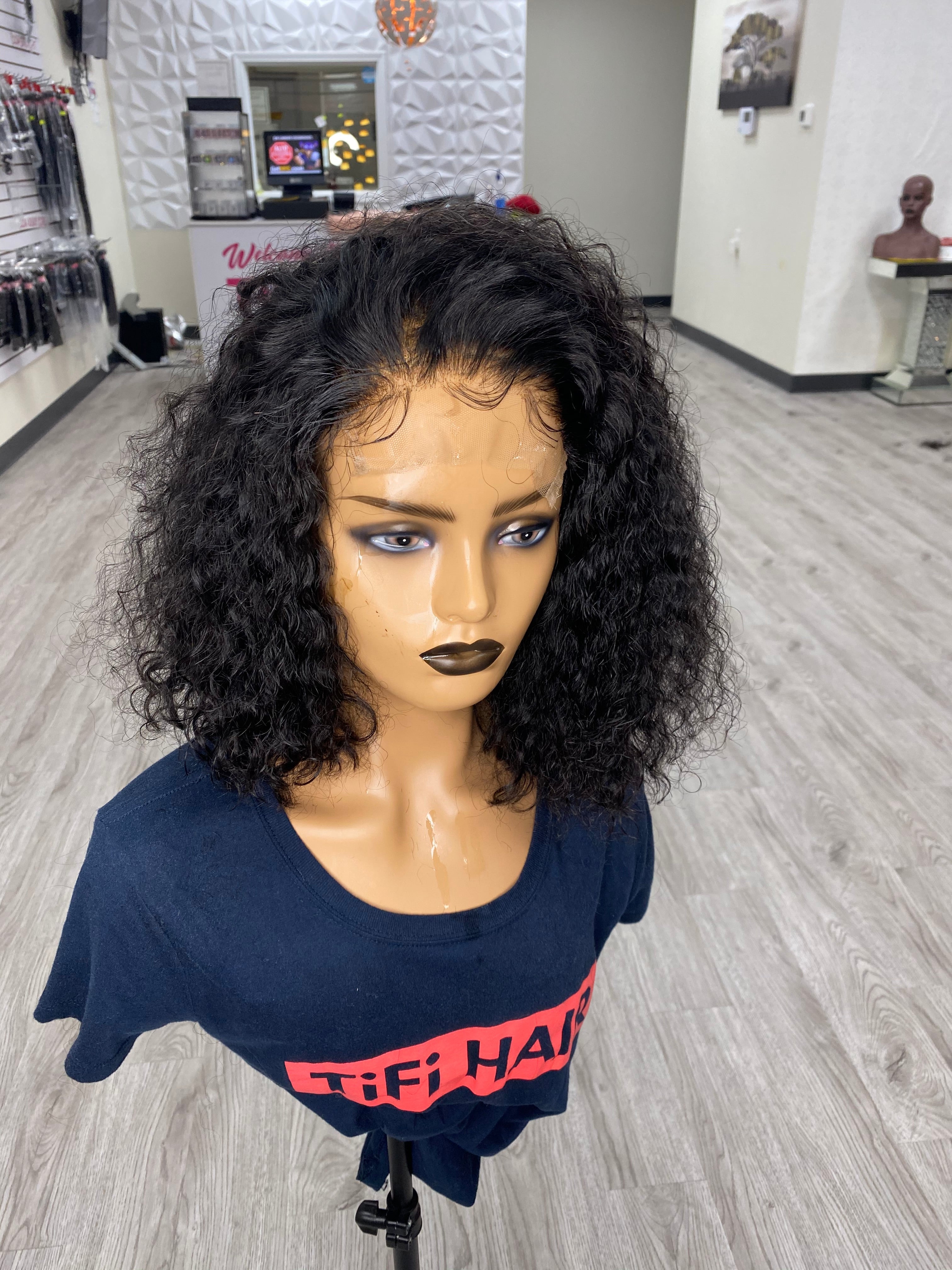 Curly bob wig with dark black curls on mannequin head