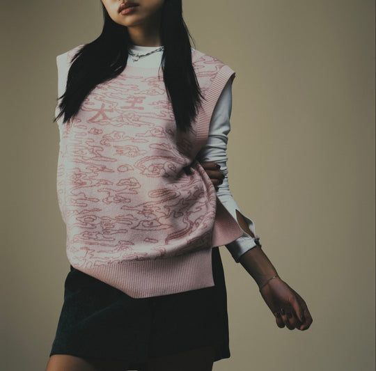 Light pink jacquard sweater vest with graphic pattern and sleeveless crew neckline