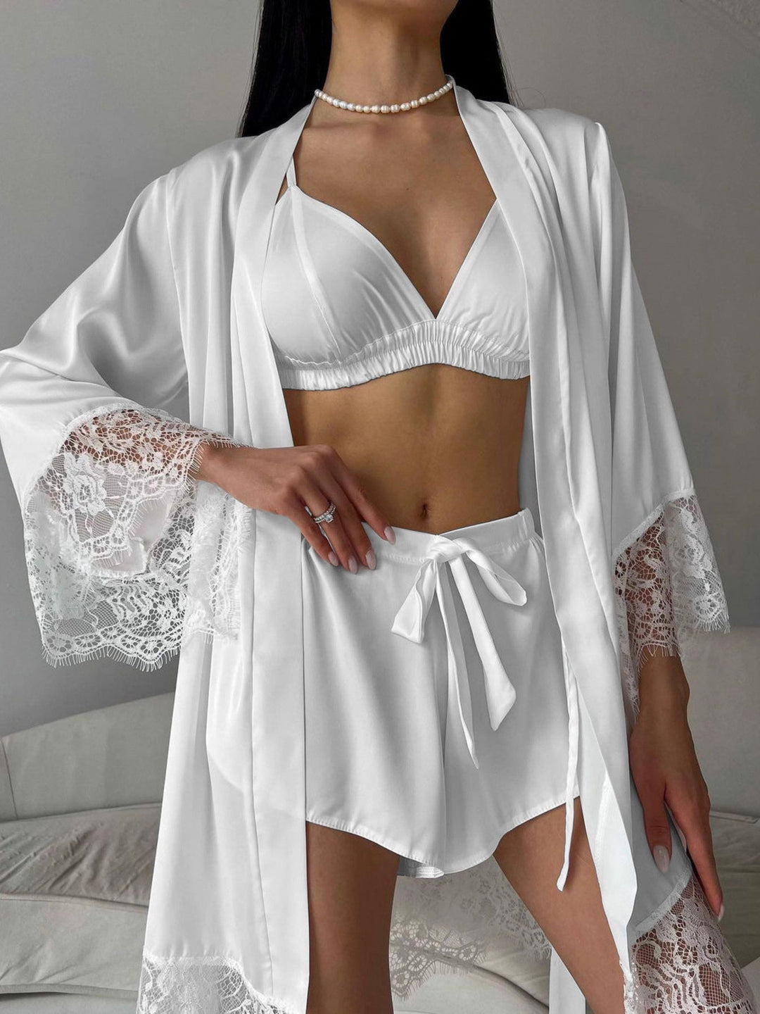 White cami bra top with ruched V-neck and lace-trim skirted shorts under cardigan