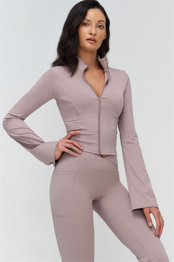 Mauve two-piece set: high-collar zip jacket and flared leggings, hands on hips