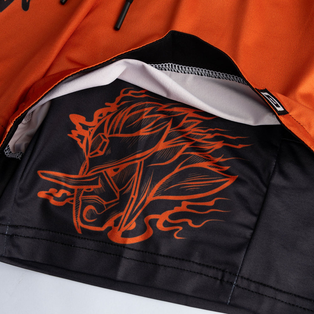 Offene Shorts-Innenseite: schwarze Futterfläche mit orangefarbenem Grafikprint