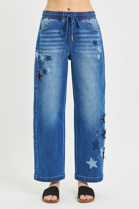 Slouchy cropped barrel jeans, dark denim with star patches and frayed detail