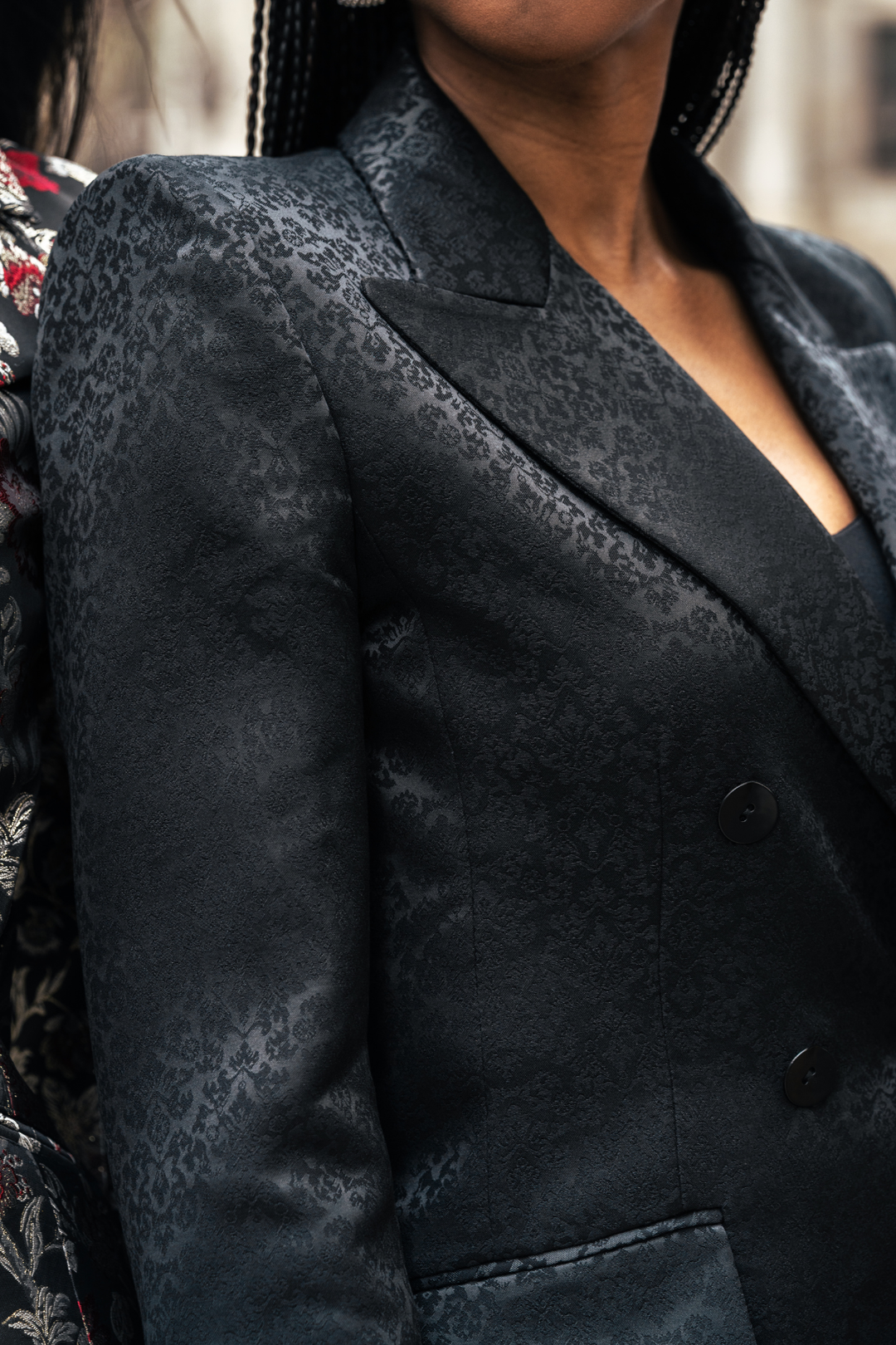 Black PREMIER blazer close-up: textured fabric on shoulders and lapel with dark buttons