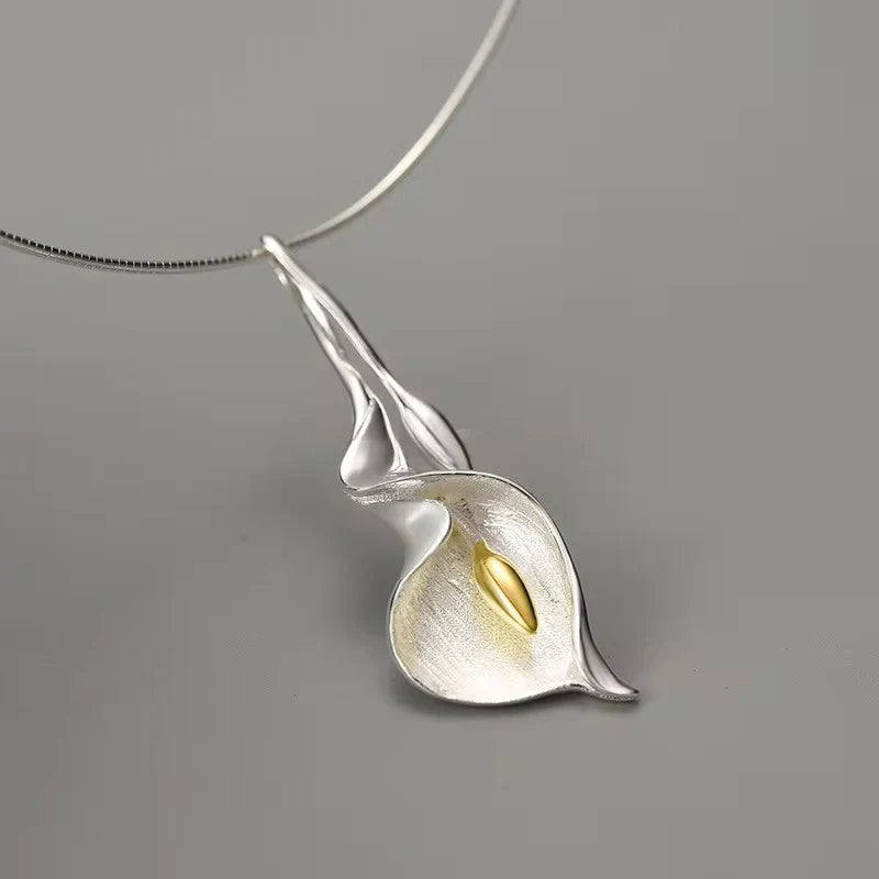 Silver calla lily pendant necklace with gold center, hanging on a silver chain