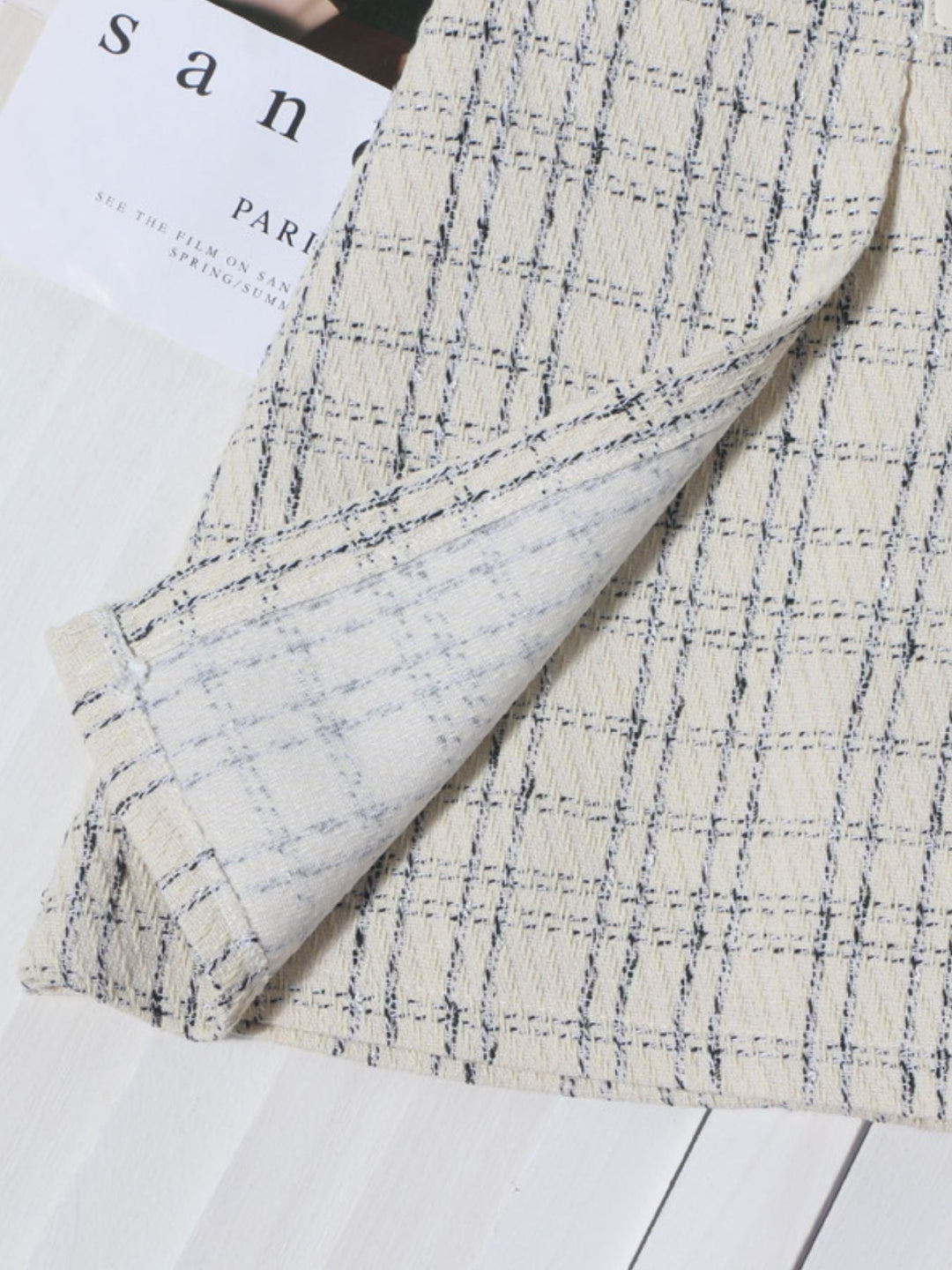 Beige plaid mini skirt showing side seam and pleated drape