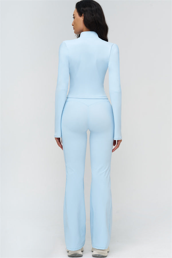 Back view of light blue fitted zip jacket and flared leggings