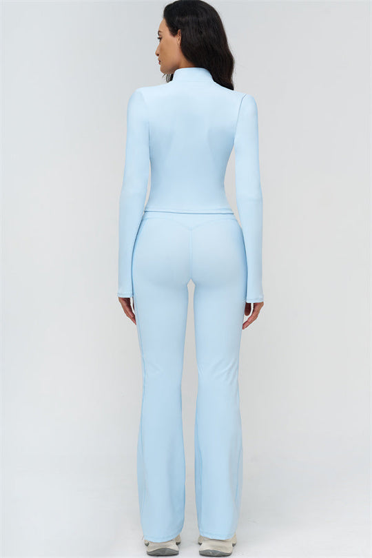 Back view of light blue fitted zip jacket and flared leggings
