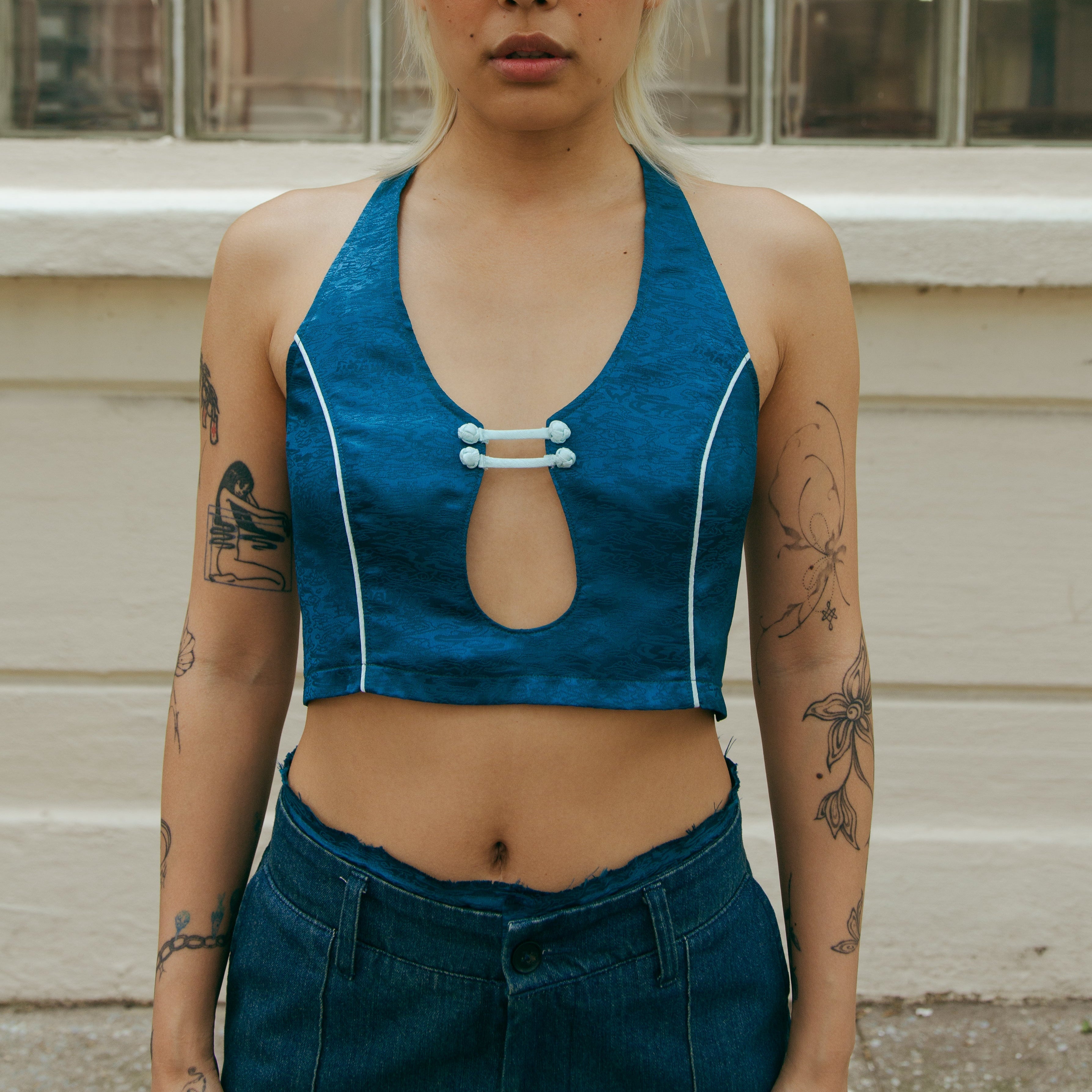 Forest blue sleeveless crop top with front keyhole cutout and white trim detail