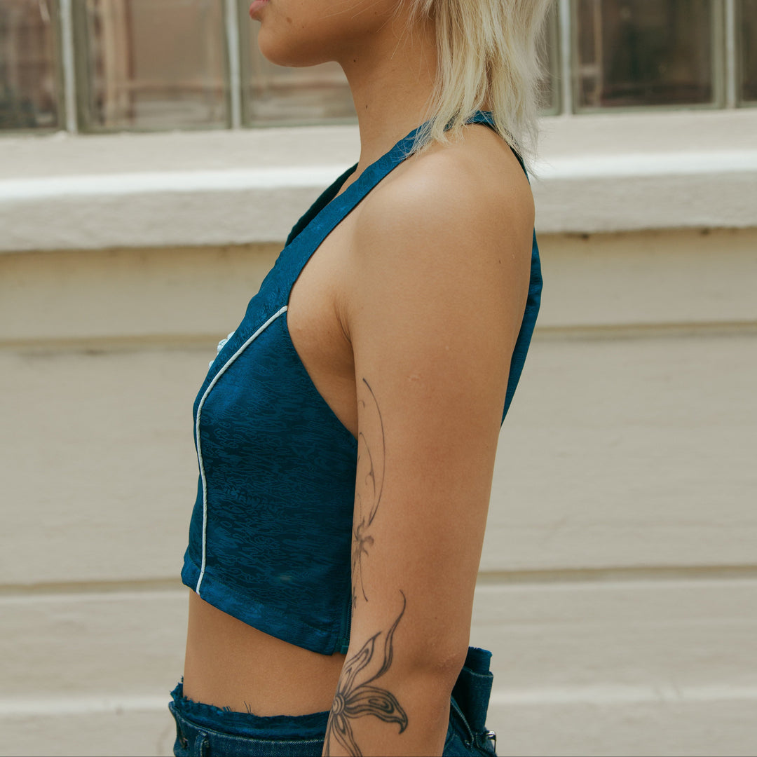 Forest blue sleeveless crop top from the side, fitted shape with white contrast trim