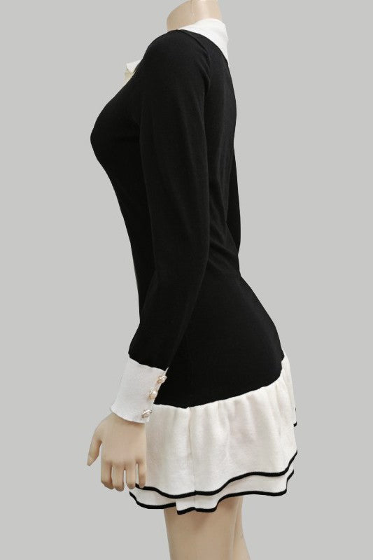 Black knit sweater mini dress with cream trim at cuffs and hem