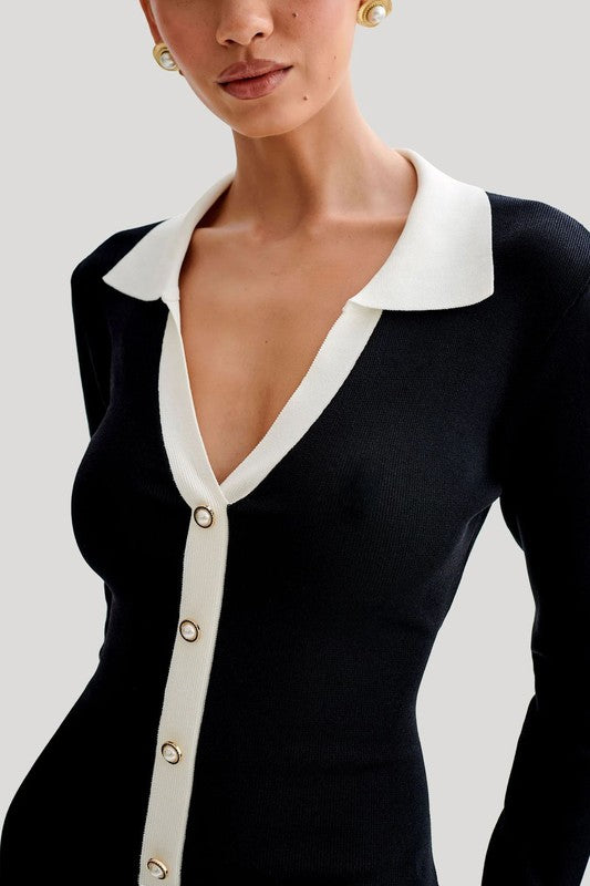 Black sweater mini dress neckline close-up, deep V with cream collar and buttons