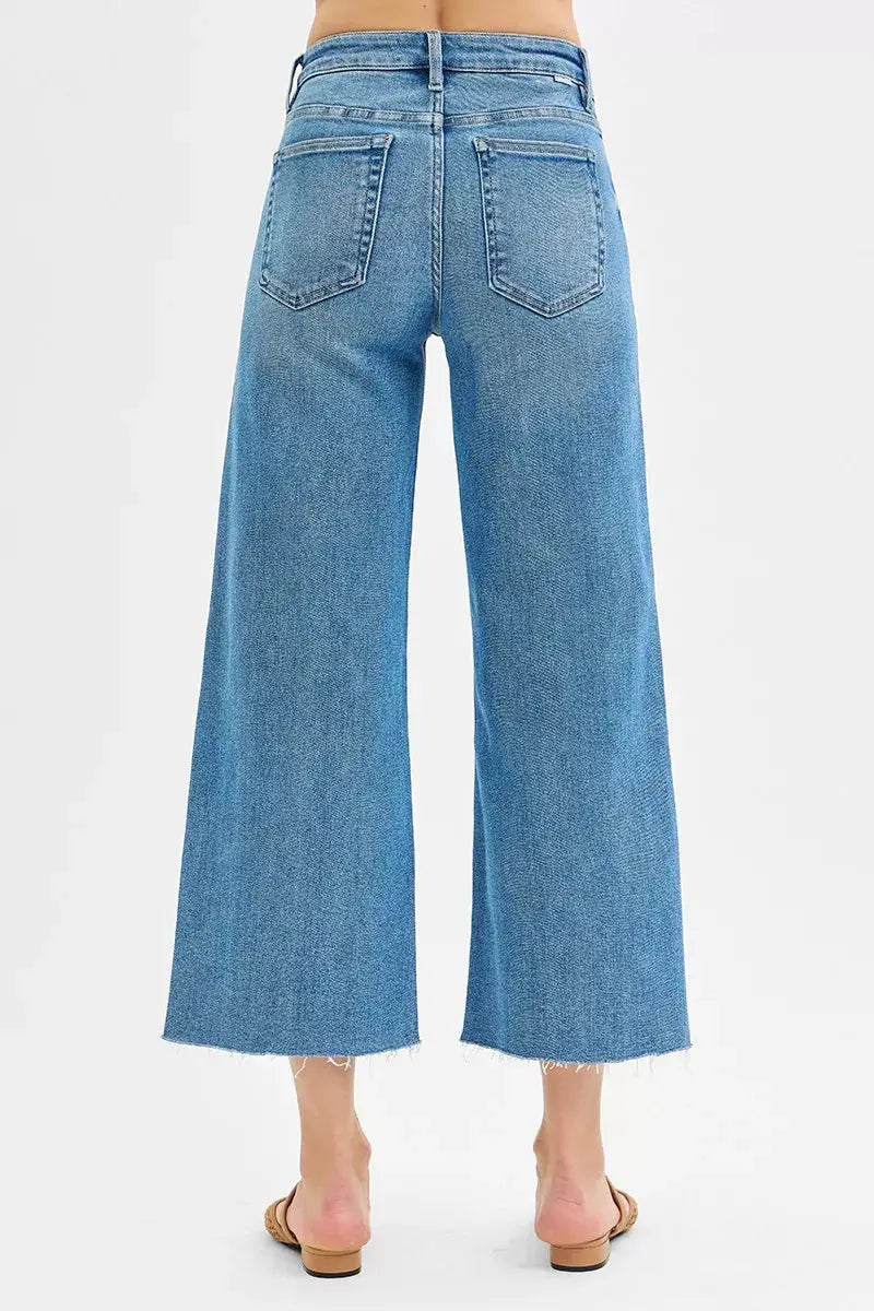 Medium-wash back view: wide-leg crop jeans with back pockets and frayed hem