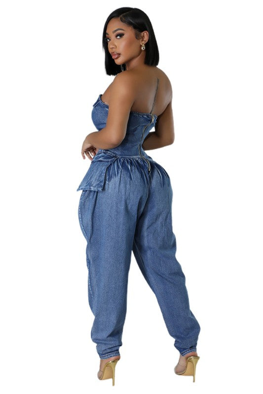Side view: navy strapless denim jumpsuit with cinched corset top and roomy harem legs
