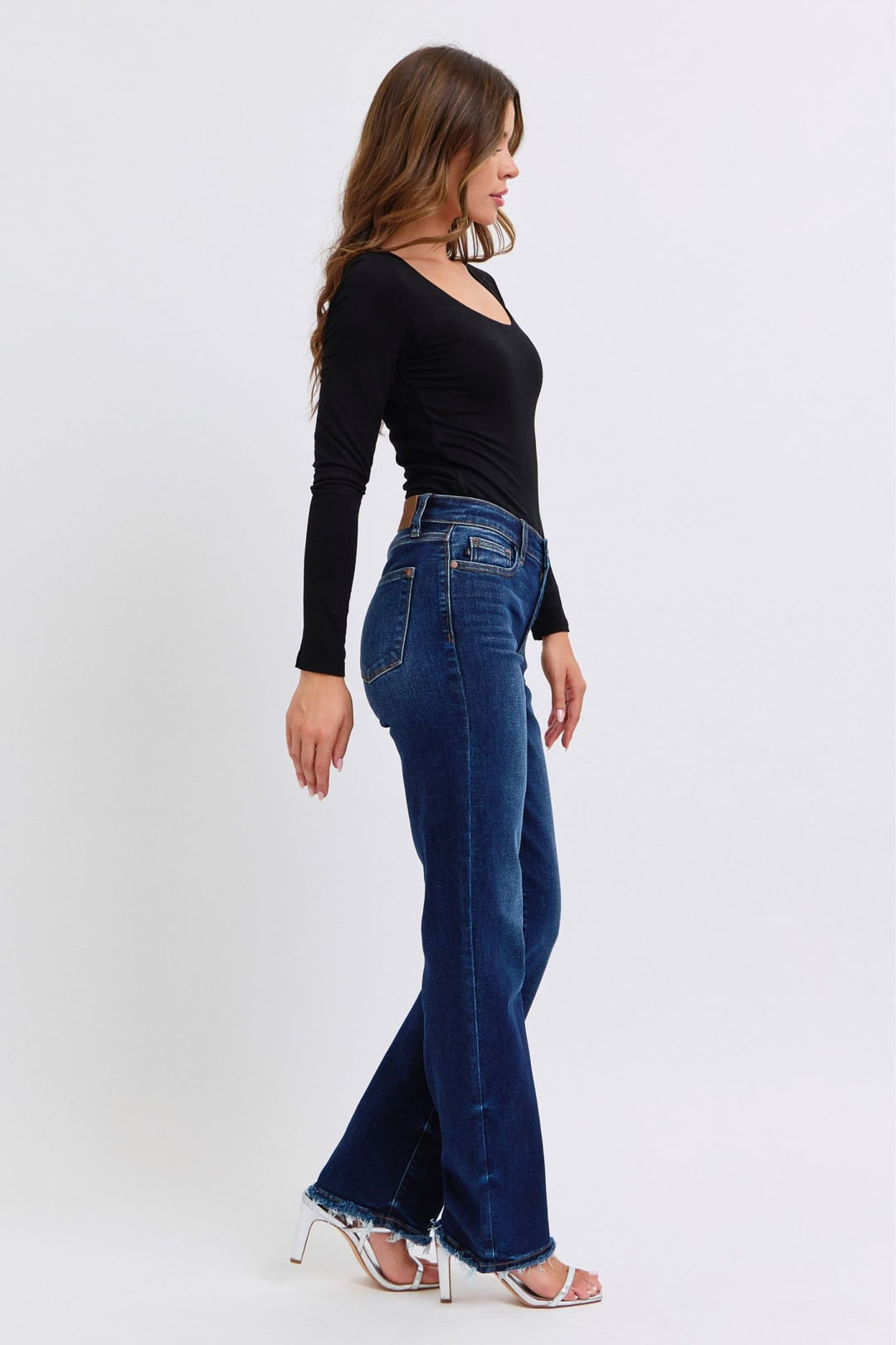Dark wash jeans side view with back yoke and pockets, straight leg, raw hem