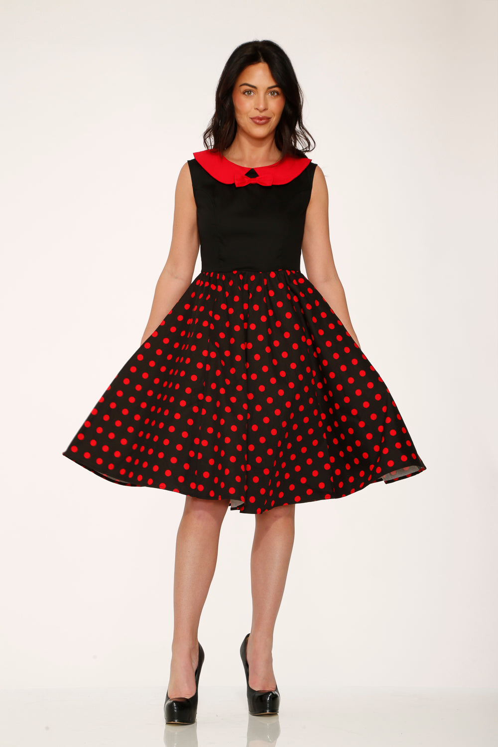 Black A-line swing dress with red polka dot pattern and bright red collar