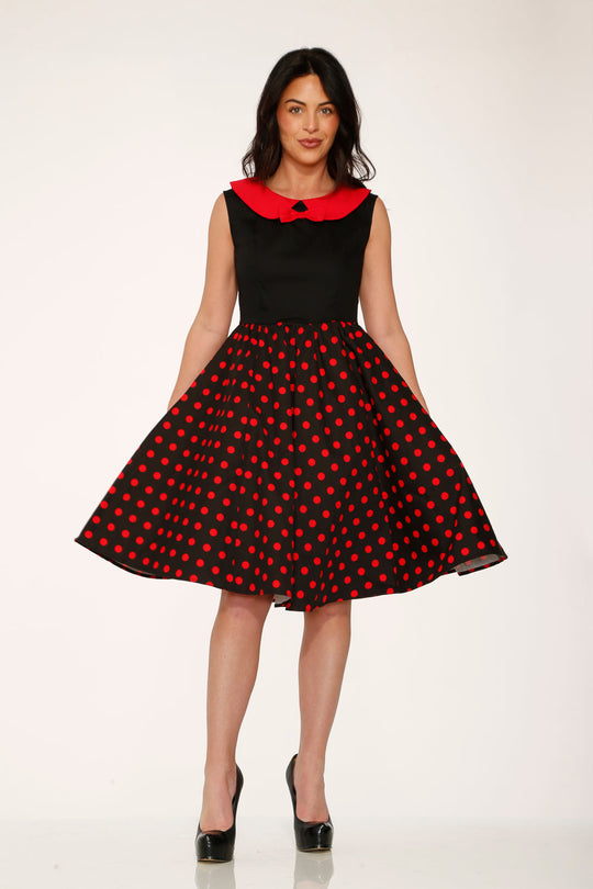 Black A-line swing dress with red polka dot pattern and bright red collar
