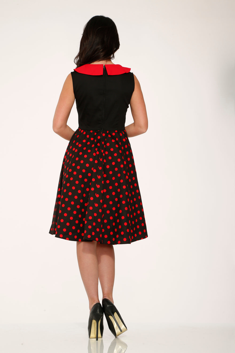 Back of black swing dress with red polka dot skirt and red collar, rear view