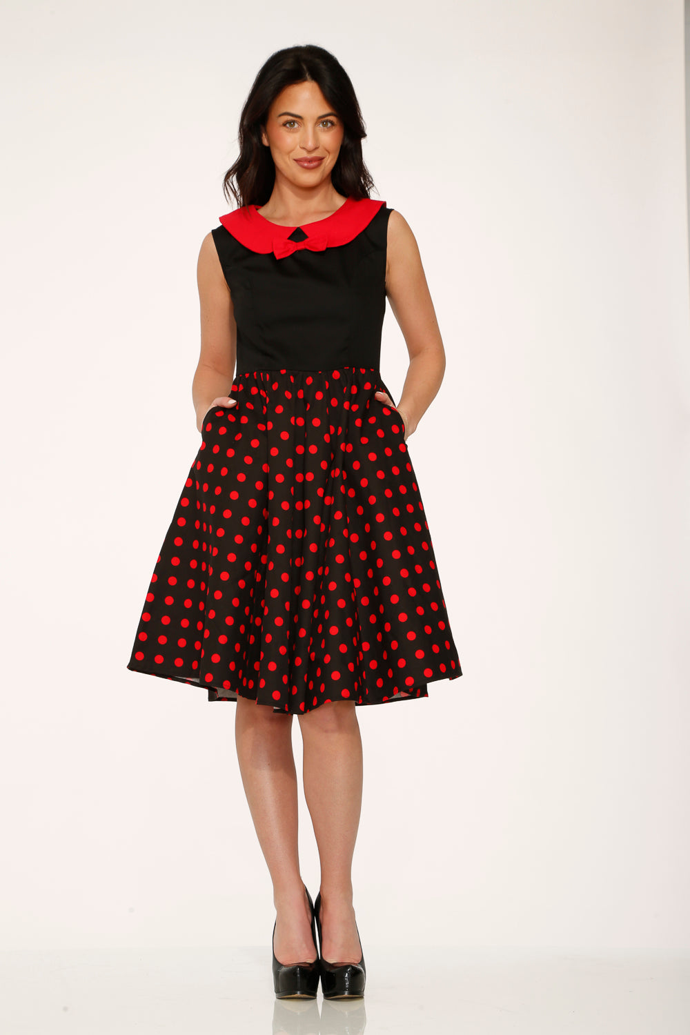 Black sleeveless swing dress with red polka dot skirt and red collar