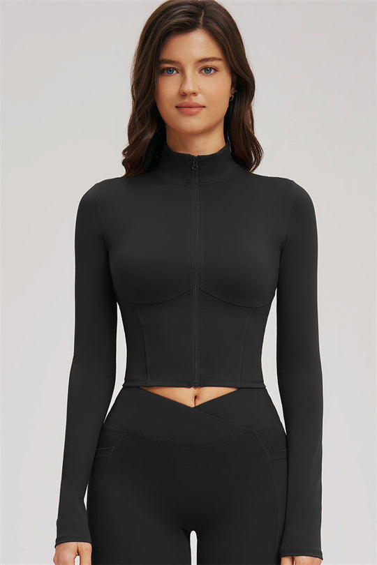 Black zip-front cropped jacket over sports bra with matching flared leggings