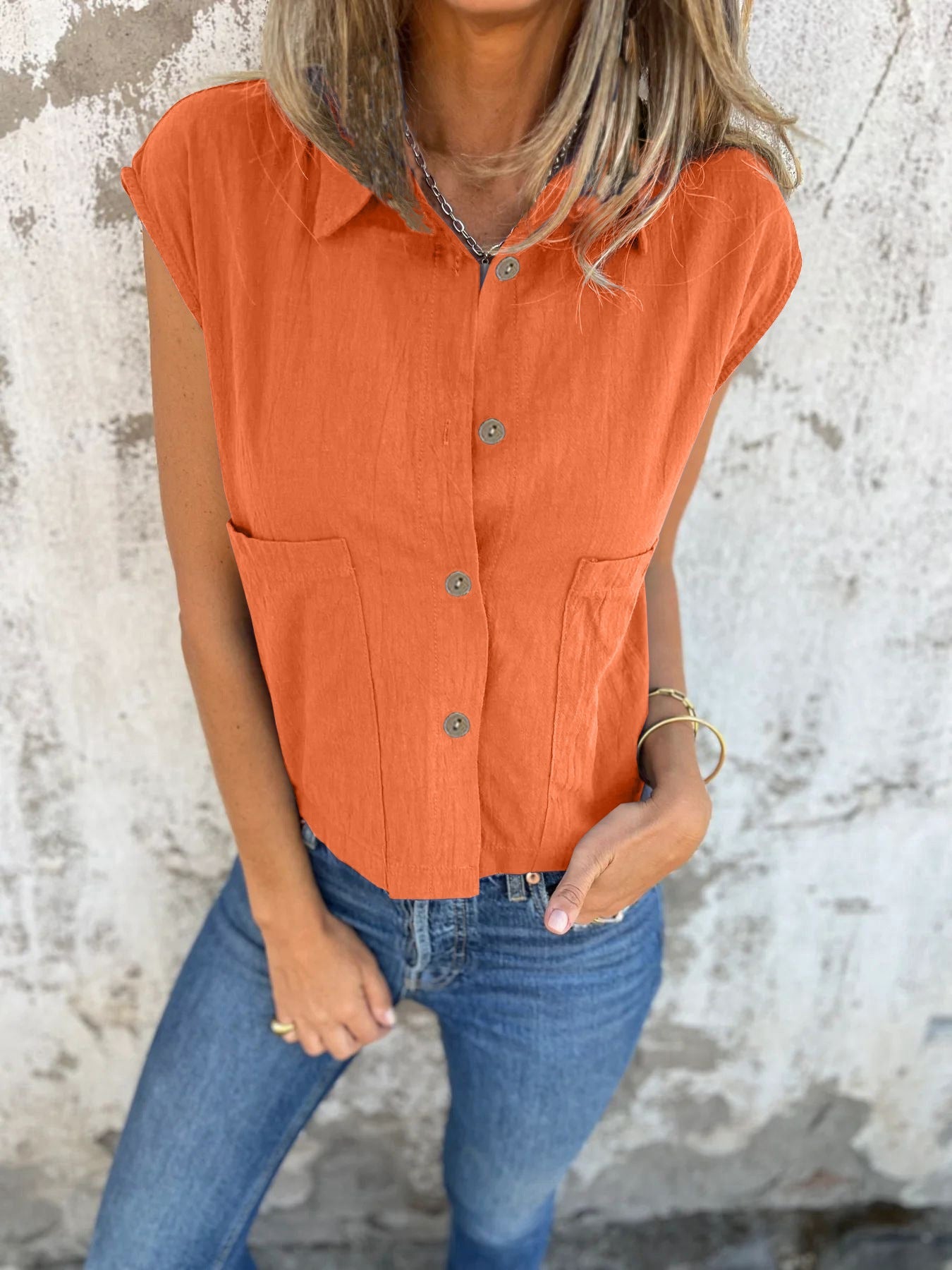 Orange button-down cap sleeve shirt with pointed collar and front button placket