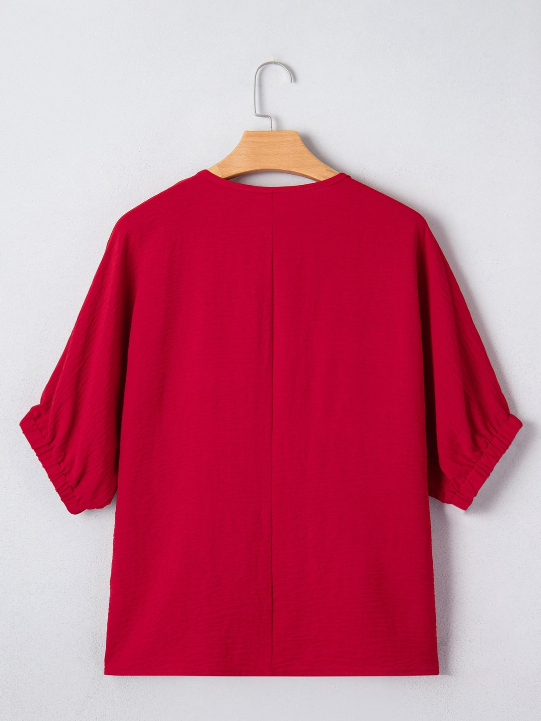 Deep Red half-sleeve blouse back view on hanger with relaxed shoulders