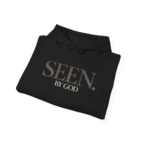 Folded black hoodie with SEEN. by God graphic on chest and drawstring hood