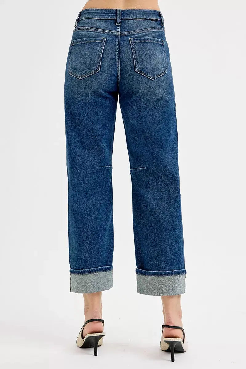 Dark wash jeans with back yoke, stitched back pockets, and cuffed hems