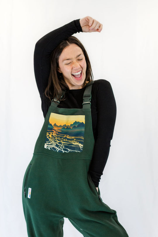 Dark green braided river fleece overalls with chest pocket featuring landscape river graphic