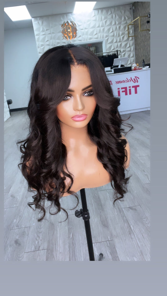 Cutie Unit hair wig with center part, long voluminous black curls on stand