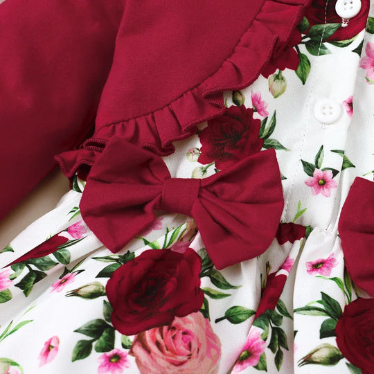 Floral skirt close-up with deep red rosette bow and ruffle trim over white fabric
