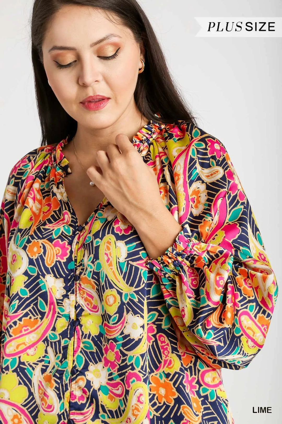 Close-up of multicolor paisley satin button-up shirt with ruffle neckline and buttons