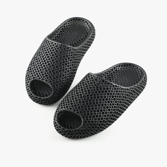 Black 3D-printed slippers, top and bottom views showing circular ventilation openings