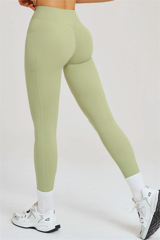 Light olive green high-waist leggings with stitched panels at the hips and thighs