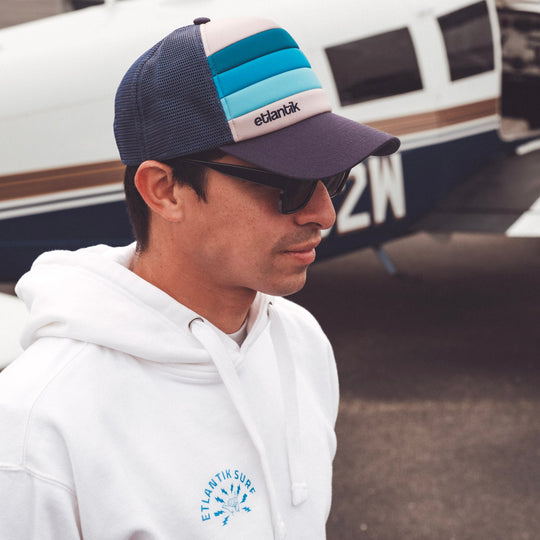 Swell Cap Blue on person: navy mesh cap with light-blue stripes and logo patch.