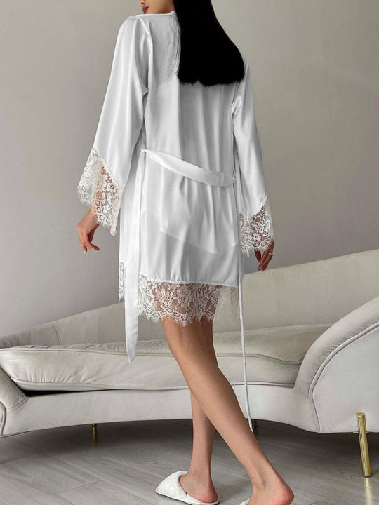 White robe-style cardigan over lace-trimmed shorts with bow tie at the waist
