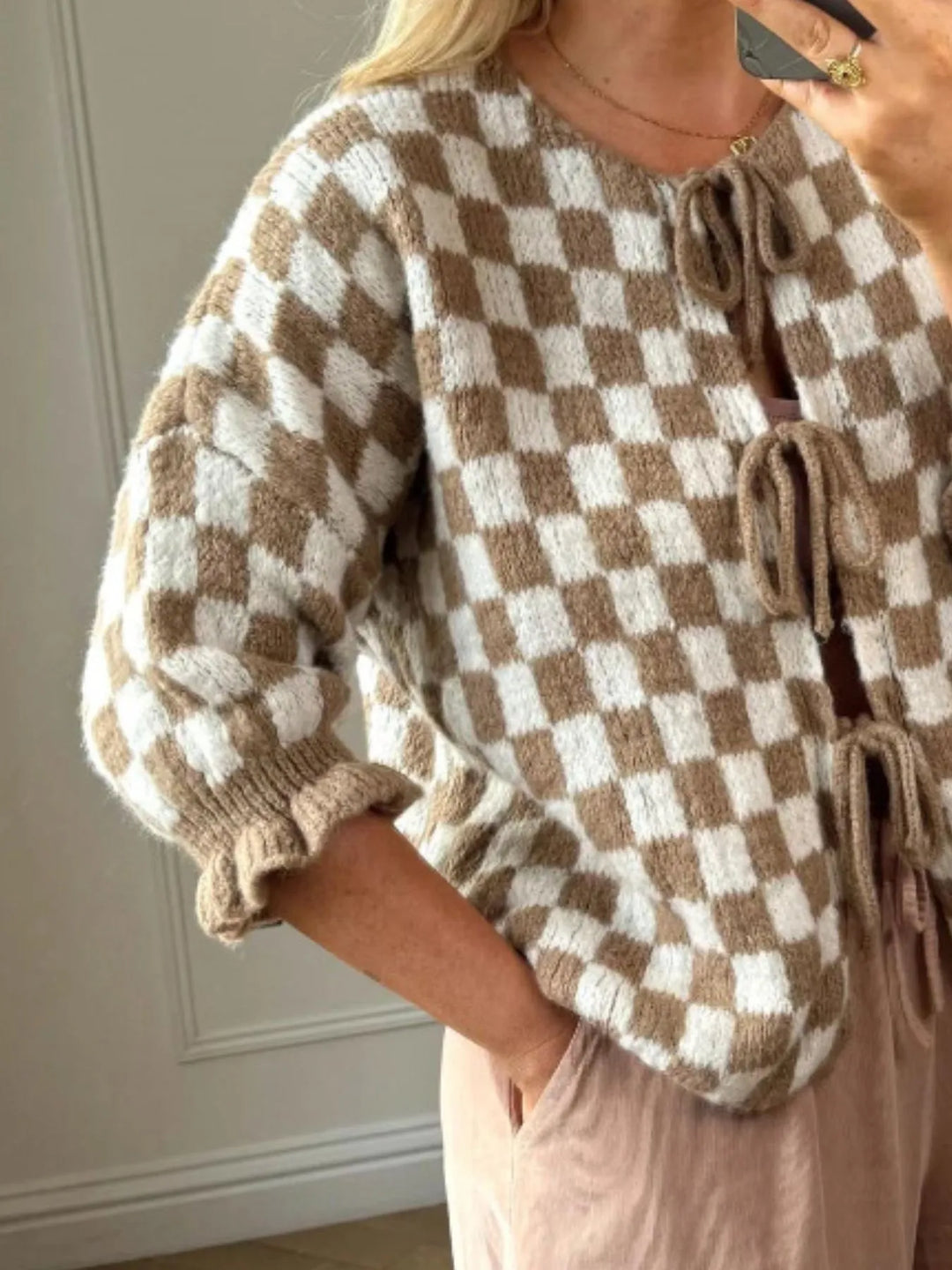 Tan and white checkered knit cardigan with long puff sleeves and tied front detail
