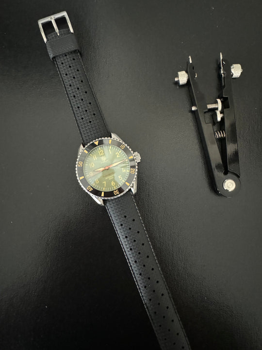 Tropic Bands watch with black perforated strap and silver buckle, light green dial