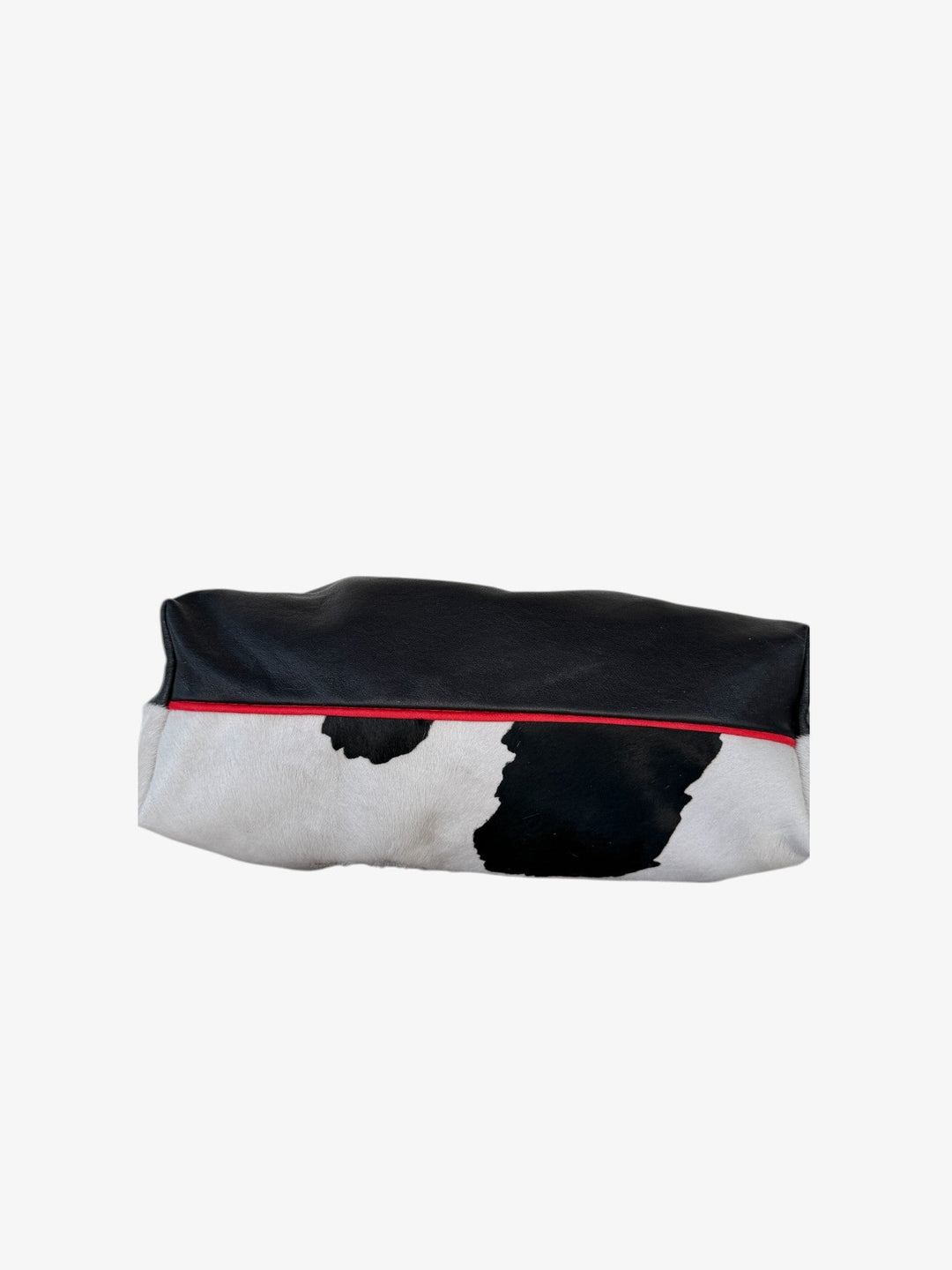 Cow-print bag with black top, red trim along the edge