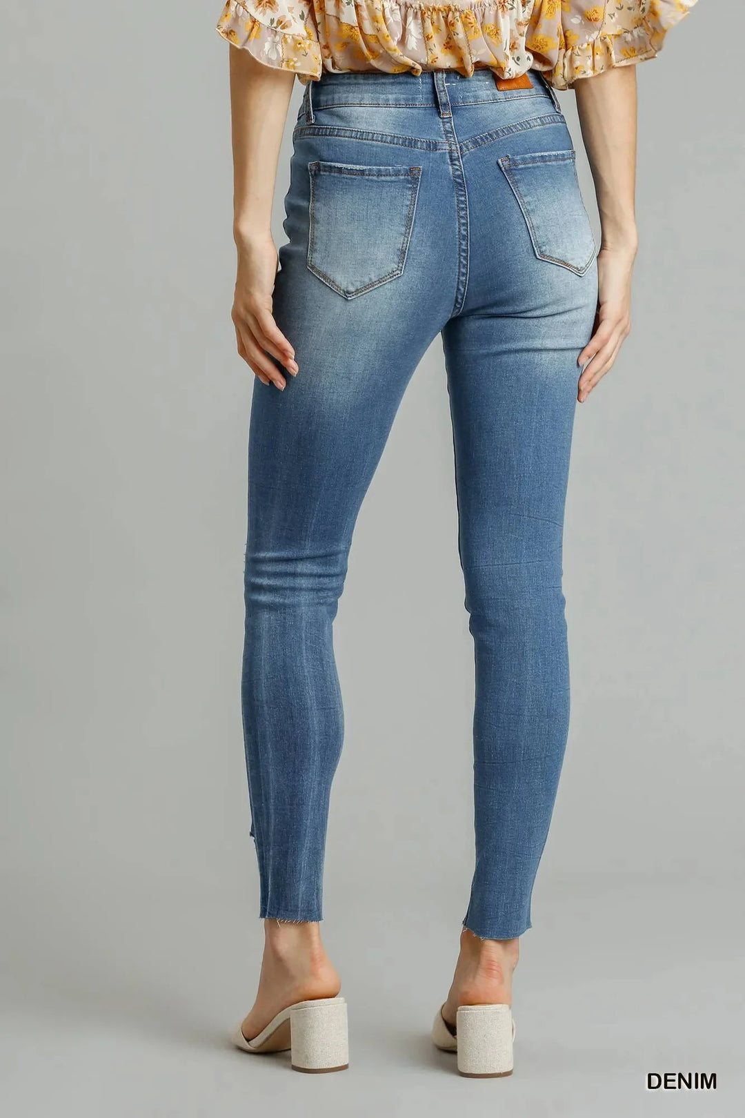 Medium wash high-waist skinny jeans, back view; five-pocket style, distressed finish