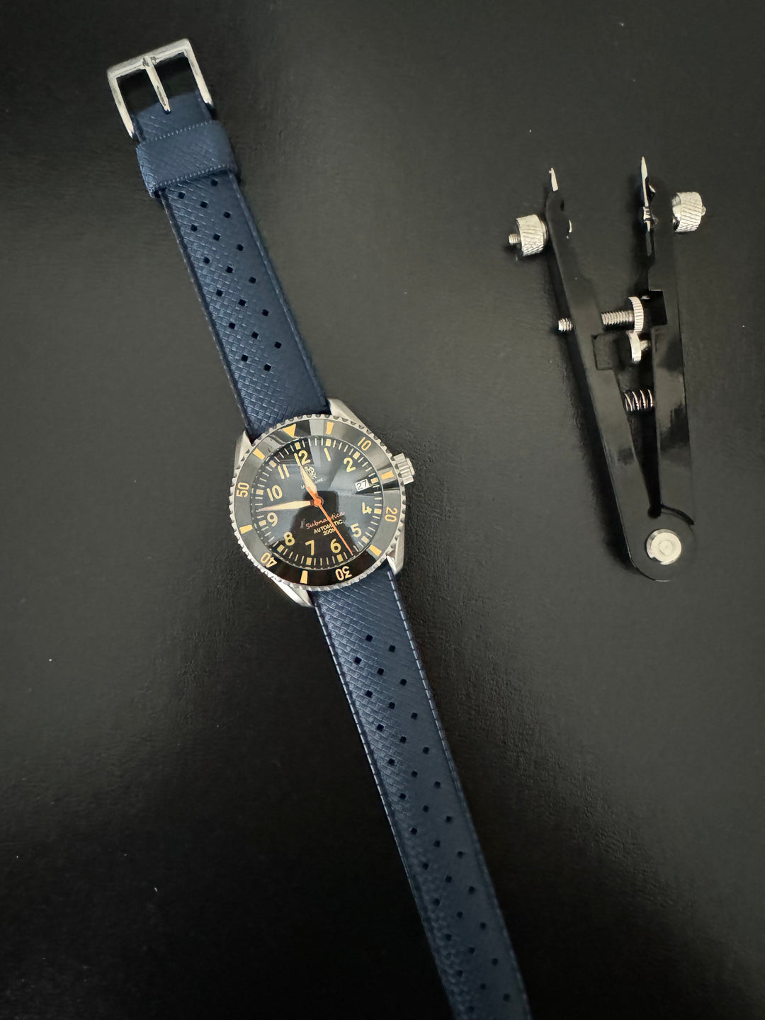 Tropic Bands watch with navy blue perforated strap and silver buckle, black dial