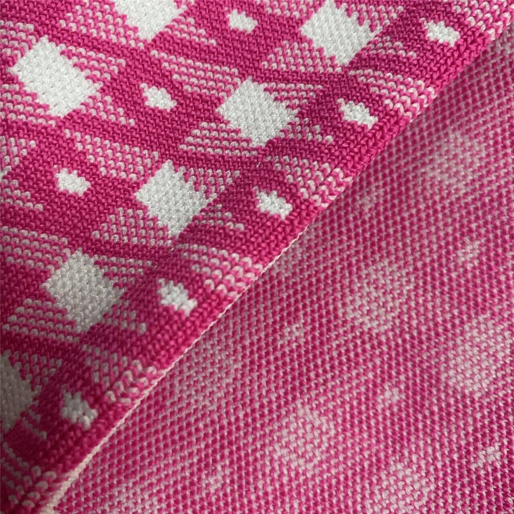 Pink knit fabric close-up with repeating diamond/check motif