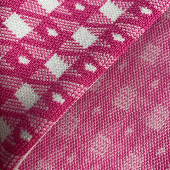 Pink knit fabric close-up with repeating diamond/check motif