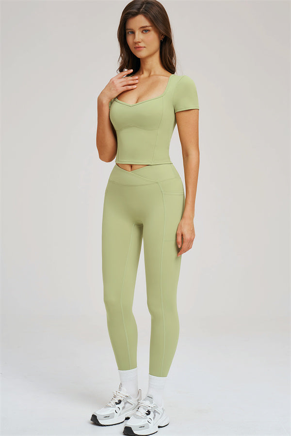 Olive green crop T-shirt and leggings set, front view with hand at neck