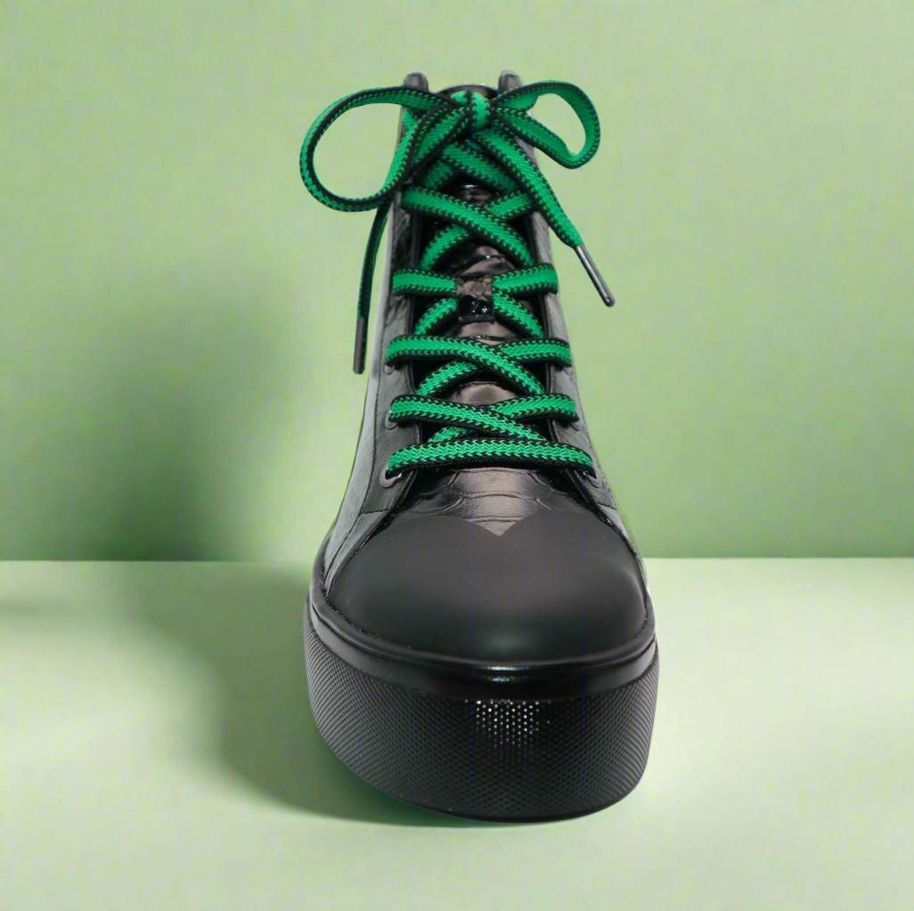 Front view: black high-top sneakers with green shoelaces and glossy finish
